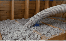 Blown-in cellulose insulation being installed in an attic cavity