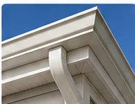 Close-up of white fascia, gutter, soffit, and trim on a new home exterior.