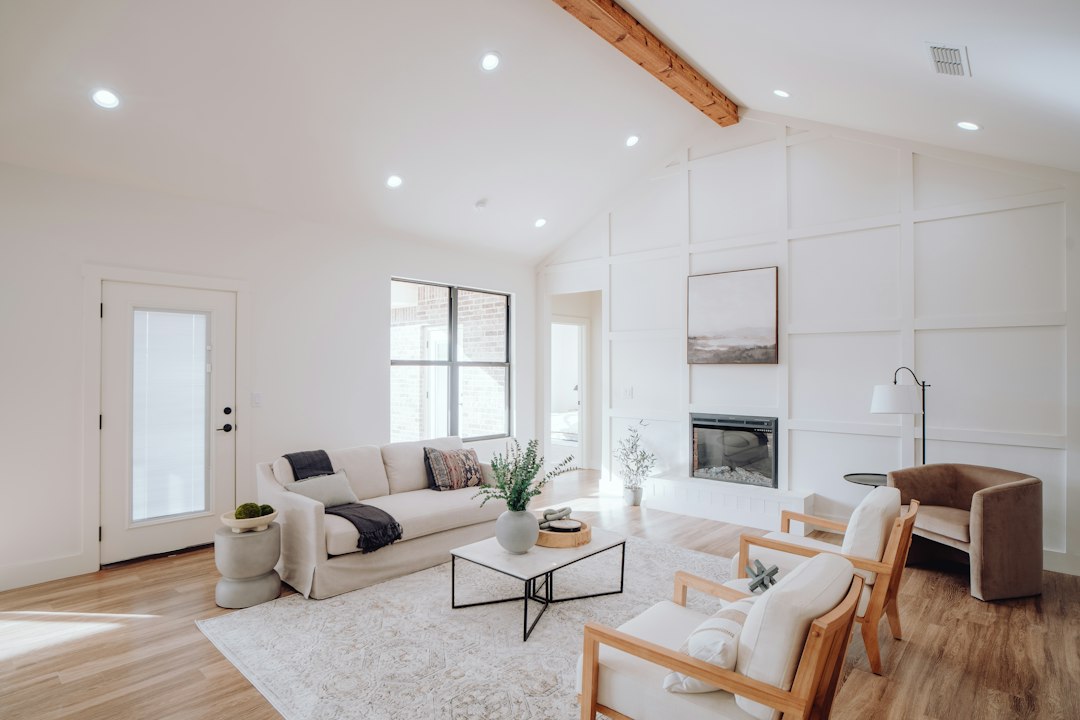 Open-plan living room with a vaulted ceiling and exposed beam in a new ranch home